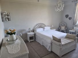 A bedroom with a bed and nightstands at Ashleigh House 