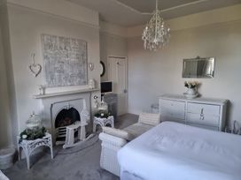 A bedroom with a fireplace and dresser at Ashleigh House
