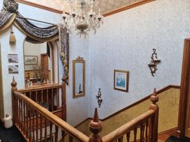 A staircase with a chandelier and decorative items at Ashleigh House