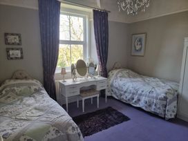 A bedroom with two beds and a dressing table at Ashleigh House