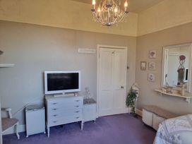 A bedroom with a television and a dresser at Ashleigh House