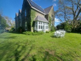A house with a garden and table set at Ashleigh House