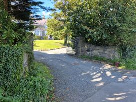 A gravel driveway leading to a house surrounded by trees at Ashleigh House