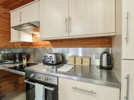 A kitchen counter with a toaster kettle microwave knife block and storage containers at Oak Lodge in Rosliston