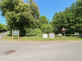 A road with multiple signs and trees at Rosliston Forestry Centre