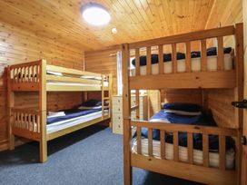 A bedroom with two wooden bunk beds a window with curtains and a chest of drawers at Chestnut Lodge in Rosliston