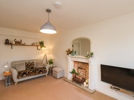 A living room with a sofa a fireplace and a television at Happy Days in Scarborough
