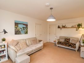 A living room with two sofas a painting on the wall and shelves with decorations at Happy Days in Scarborough