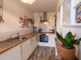 A kitchen with a wooden countertop and white cabinets at Happy Days in Scarborough