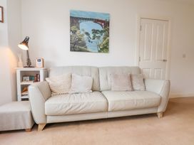 A living room with a sofa and a painting at Happy Days in Scarborough