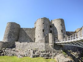 An old stone castle with round towers and a modern bridge at Bryn Awelon in Harlech