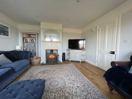 A living room with a fireplace tv bookshelf and two sofas at Bryn Awelon in Harlech