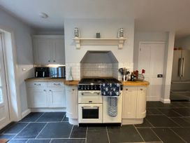 A kitchen with a stove oven and utensils on wooden countertops at Bryn Awelon in Harlech