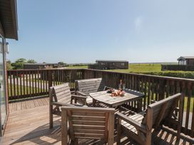 An outdoor area with a wooden table and chairs at Maple Lodge in Whitby