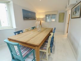 A dining room with a wooden table and colorful chairs at Gorse Hill 