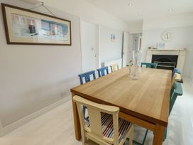 A dining room with a wooden table and colorful chairs at Gorse Hill