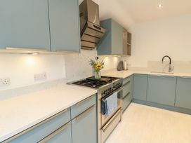 A kitchen with cabinets, stove, sink, and countertop at Gorse Hill