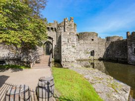 A castle with a bridge and water feature at Gorse Hill in Rhosneigr