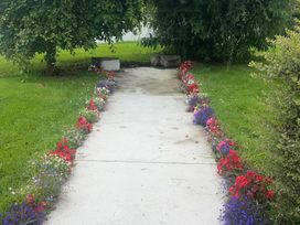 A pathway bordered by flowers and grass at Dromclough Farmhouse in Dromclough near Listowel, County Kerry