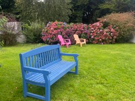 A garden with a blue bench and flowering bushes at Dromclough Farmhouse in Dromclough near Listowel, County Kerry