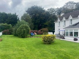 A garden with chairs and flowers at Dromclough Farmhouse in Dromclough near Listowel, County Kerry