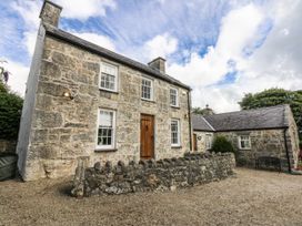 A house with stone walls and wooden door at Tyddyn Iolyn in Benllech