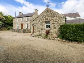 Two stone houses with a gravel pathway at Tyddyn Iolyn Benllech