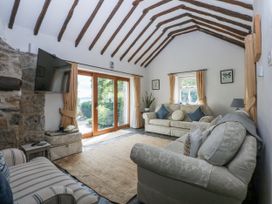 A living room with a sofa and TV at Tyddyn Iolyn in Benllech