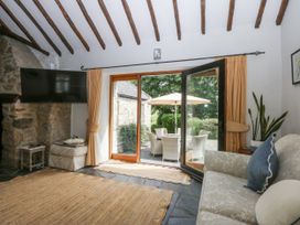 A living room with a television and a sliding door at Tyddyn Iolyn Benllech