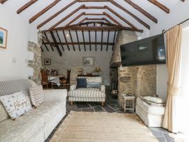 A living room with a sofa and television at Tyddyn Iolyn in Benllech