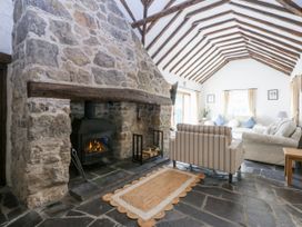 A living room with a fireplace and sofa at Tyddyn Iolyn Benllech