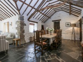 A dining room with a table and chairs at Tyddyn Iolyn in Benllech