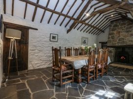 A dining room with a table and chairs at Tyddyn Iolyn in Benllech