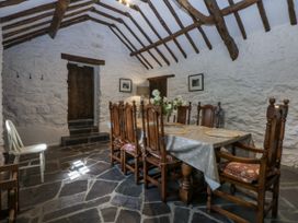 A dining room with a table and chairs at Tyddyn Iolyn in Benllech