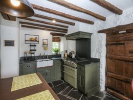A kitchen with a stove and sink at Tyddyn Iolyn in Benllech