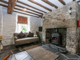 A living room with a fireplace and a sofa at Tyddyn Iolyn in Benllech