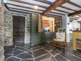 A kitchen with a cabinet and rocking chair at Tyddyn Iolyn in Benllech