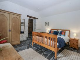 A bedroom with a bed and wardrobe at Tyddyn Iolyn in Benllech