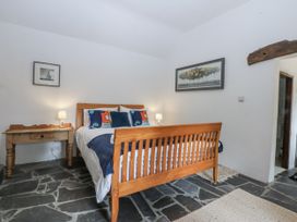 A bedroom with a bed and side table at Tyddyn Iolyn in Benllech