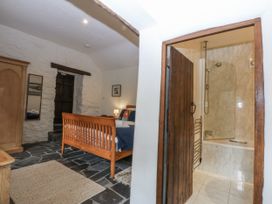 A bedroom with a bathroom and shower at Tyddyn Iolyn in Benllech