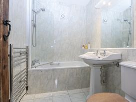 A bathroom with a shower, bathtub, sink, and toilet at Tyddyn Iolyn in Benllech