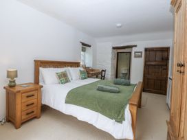 A bedroom with a bed and furniture at Tyddyn Iolyn in Benllech