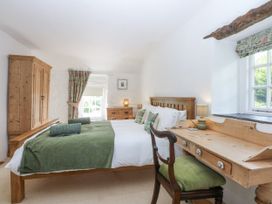A bedroom with a double bed and wooden furniture at Tyddyn Iolyn in Benllech