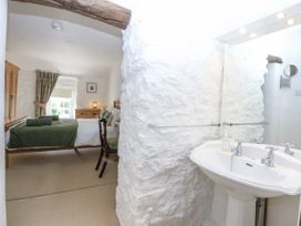 A bedroom with a sink and doorway to the main sleeping area at Tyddyn Iolyn in Benllech