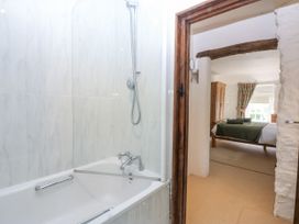 A bathroom with a bathtub and shower in view at Tyddyn Iolyn in Benllech