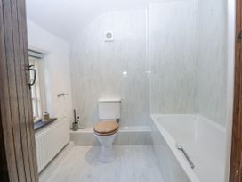 A bathroom with a bathtub, toilet, and sink at Tyddyn Iolyn in Benllech