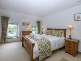 A bedroom with a double bed and two windows at Tyddyn Iolyn in Benllech