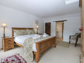 A bedroom with a bed and nightstand at Tyddyn Iolyn in Benllech