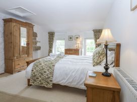 A bedroom with a bed and wardrobe at Tyddyn Iolyn in Benllech