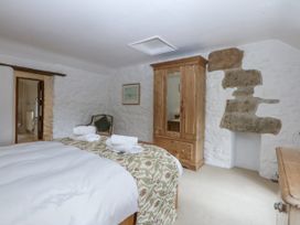 A bedroom with a bed and wardrobe at Tyddyn Iolyn in Benllech